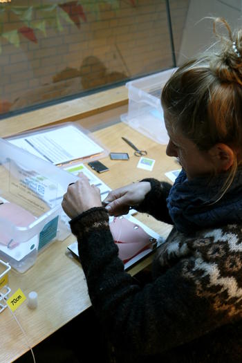 Students practice suture technique on a skin model.